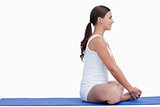 Brunette woman sitting on a yoga mat