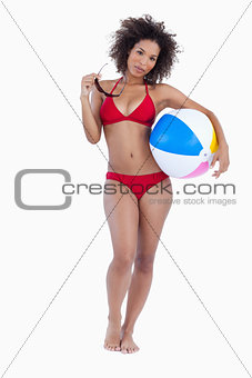 Attractive woman holding her sunglasses and a beach ball