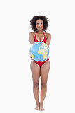 Happy brunette holding a globe beach ball