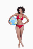 Attractive brunette woman holding a beach ball