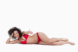 Smiling woman lying down while placing her thumbs up