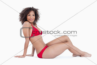 Attractive woman sitting down while placing her arms back
