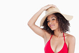Beautiful woman wearing a swimsuit while holding her hat