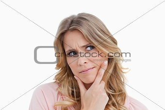 Serious young woman placing her fingers on her chin