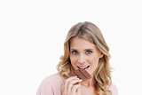 Young blonde woman eating chocolate