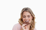 Young woman eating a delicious peace of chocolate