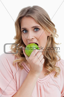 Young blonde woman eating an apple