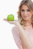 Young woman holding a green apple while looking at the camera