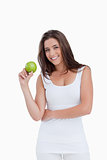 Smiling brunette woman holding a green apple