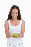 Smiling brunette woman holding a beautiful green apple