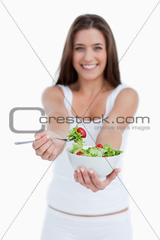 Delicious salad being eaten by a young woman