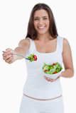 Fork with salad being held by a young woman