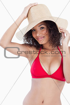 Attractive brunette woman holding her hat