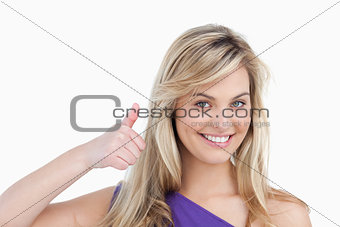 Smiling blonde woman placing her thumbs up