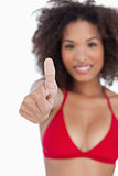 Thumbs up being shown by a young brunette woman