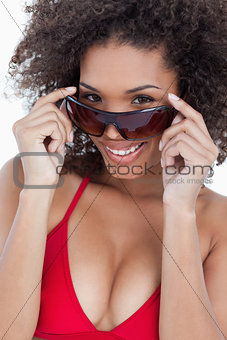 Attractive brunette holding her sunglasses while smiling