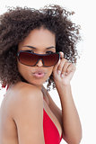 Young woman puckering her lips while holding her sunglasses