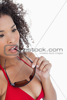 Attractive woman looking away while placing her sunglasses on he