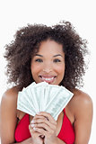 Smiling brunette holding a fan of bank notes