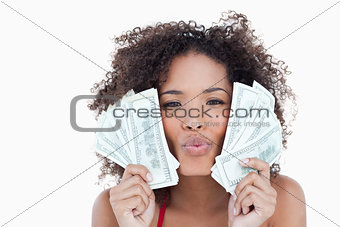 Young attractive woman puckering her lips while holding bank not