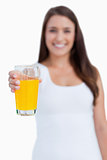 Glass of orange juice being held by a young woman