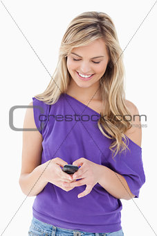 Smiling blonde woman holding her cellphone