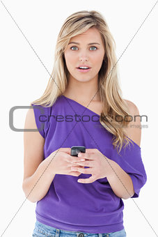 Surprised blonde woman holding her cellphone