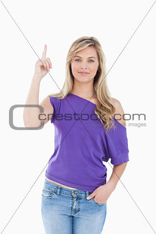 Peaceful young woman raising her finger