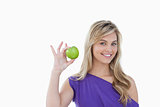 Smiling blonde woman holding a green apple