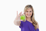 Green apple being held by a blonde woman