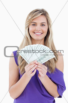 Happy blonde woman holding a fan of notes
