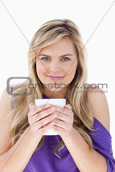 Young blonde woman holding a cup of coffee