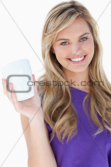 Smiling blonde woman holding a cup of coffee