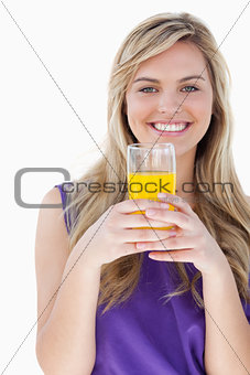 Smiling blonde woman holding an orange juice