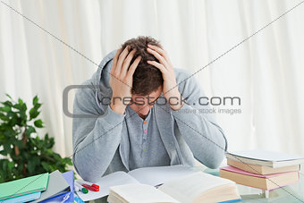 Distressed student in front of his books
