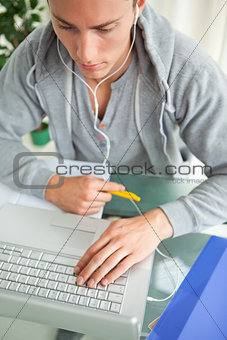 High-angle view of a student doing his homework while helping wi