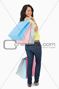 Rear view of a beautiful Latin student with shopping bags