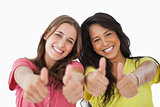Portrait of two female students the thumbs-up 