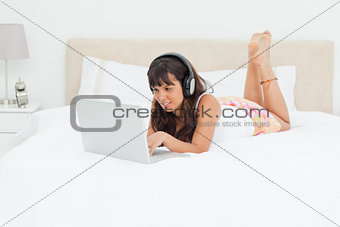 Young woman chatting with a laptop with earphones