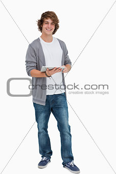 Male student posing while holding a touch pad