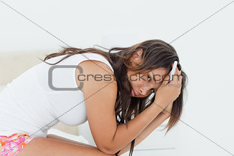 Sad young woman holding a pregnancy test 