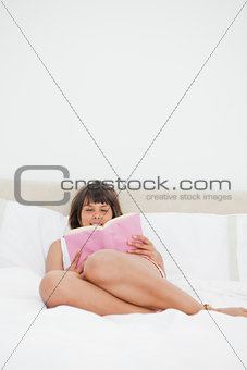 Smiling student disheveled in pajama reading a book