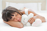 Cute young woman sleeping with a teddy bear
