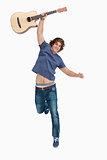 Male student jumping with his guitar