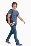 Male student with a backpack holding books while walking