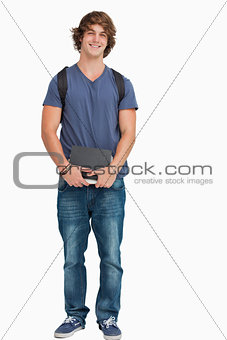 Male student posing with a backpack and books