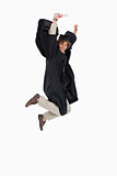 Happy male student in graduate robe jumping