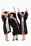 Three students in graduate robe raising their arms