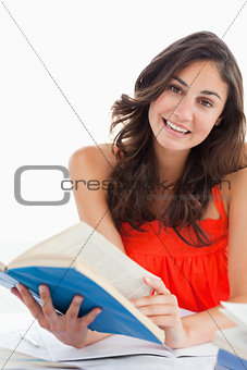 Portrait of a beautiful student reading a blue book