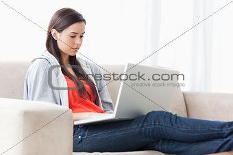 A woman with her laptop on the couch with legs outstretched 